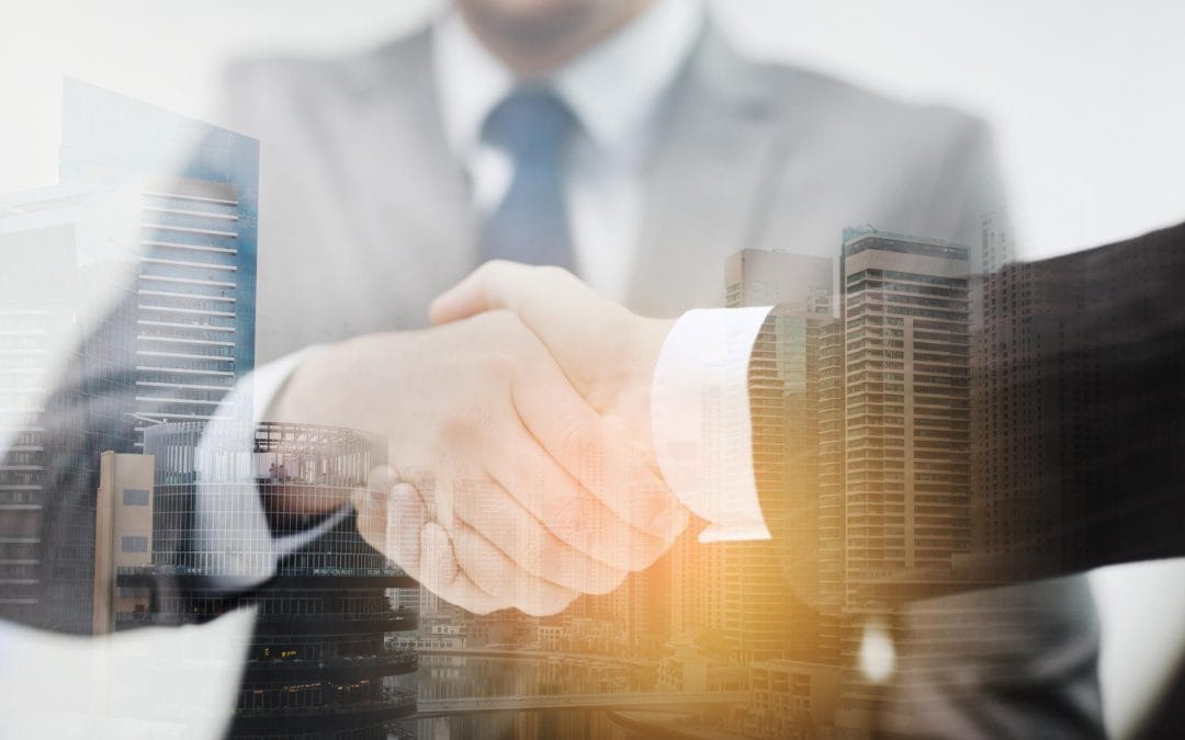 Two people in suits shaking hands, with tall city buildings overlaid in the background.
