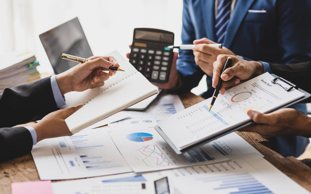 Business people reviewing financial reports and data at a meeting table.
